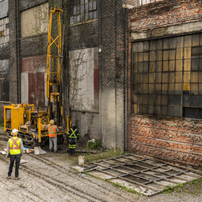 Commercial property risk - maintenance workers  in hi-vis outside a derelict property